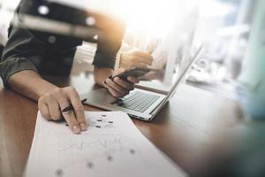 business man hand working on laptop computer with digital layer business graph information diagram on wooden desk as concept photo