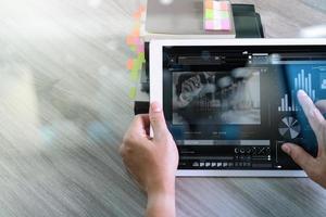 mano de hombre de negocios que asiste a una videoconferencia con una tableta digital y una tableta en el escritorio de la oficina foto