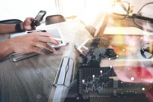 documentos comerciales en la mesa de la oficina con teléfono inteligente y tableta digital y negocio gráfico con libro de pila y hombre trabajando en segundo plano foto