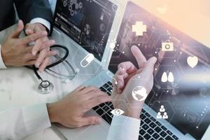 concepto de trabajo conjunto médico, médico que trabaja con teléfonos inteligentes y tabletas digitales y computadoras portátiles para reunirse con su equipo en una oficina moderna en el hospital con un diagrama virtual foto