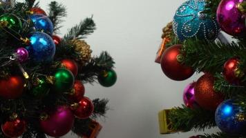 concepto de temporada de saludo ajuste manual de adornos en un árbol de navidad con luz decorativa foto