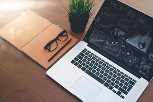 top view of new modern computer laptop with blank screen and blank book with eye glass as concept photo