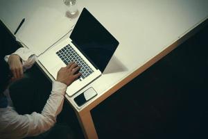 top view of man working with business documents on office table with digital tablet and man working with smart laptop computer photo