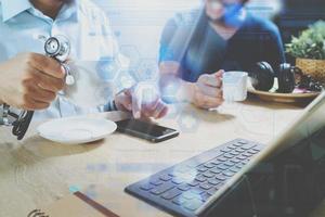 Medical doctor team taking coffee break.using digital tablet docking smart keyboard and smart phone on marble desk.listen music,filter film effect photo