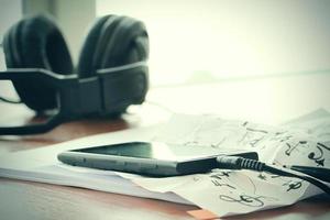 composing music concept with shallow DOF evenly matched jack of headphone and crumpled musical notes paper photo