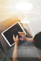 top view of hipster hands using smart phone and digital tablet pro while sitting on a cosy sofa in his home as concept photo