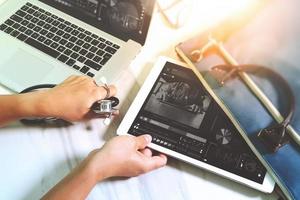 concepto de tecnología médica. doctor mano trabajando con tableta digital moderna y computadora portátil con interfaz de gráfico médico, foto de efecto de bengala solar