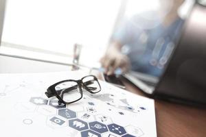 Doctor working with  laptop computer and eye glass in medical workspace office and medical network media diagram as concept photo