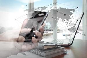 double exposure of businessman hand use smart phone with office workspace with social network diagram photo