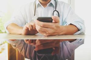 doctor en medicina mano trabajando con un teléfono inteligente moderno como concepto de red médica foto