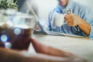 Medical doctor team taking coffee break.using digital tablet docking smart keyboard and smart phone on marble desk.listen music,filter film effect photo