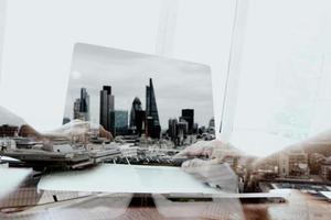 Double exposure of businessman working with new modern computer  and london city blurred background photo