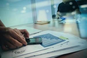 designer hand working and smart phone and laptop on wooden desk in office  with social network diagram photo