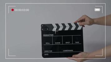 filmskiffer eller clapperboard slå. närbild hand som håller tom filmskiffer och klappar den. video