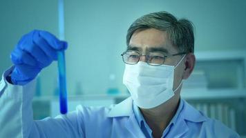 Scientist holding liquid chemical tube in laboratory, Science and technology healthcare concept