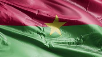 drapeau burkina faso agitant sur la boucle du vent. bannière burkina faso se balançant sur la brise. fond de remplissage complet. Boucle de 10 secondes. video