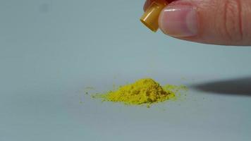A woman poured a yellow medical capsule video