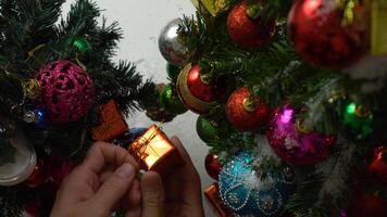 Greeting Season concept.hand setting of ornaments on a Christmas tree with decorative light photo