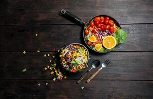 Fresh salad with corn and mixed on wooden background in pan top view. Healthy food. photo