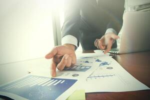 businessman hand working with business documents on office table with laptop computer with social media diagram photo