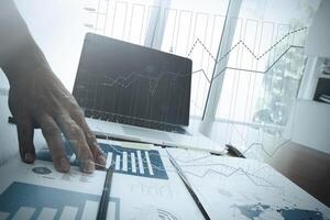 close up of business man hand working on laptop computer with business graph information diagram on wooden desk as concept photo