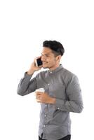 Young hipster man talking phone while coffee cup in hands isolated on white background. photo