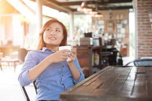 Beautiful young woman with a cup of coffee at a cafe. photo