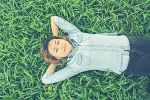 Young hipster woman lying down on grass. photo