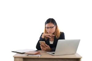 mujer de negocios seria con teléfono inteligente mientras trabaja con su computadora portátil aislada sobre fondo blanco. foto