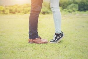 Feets of young couple kissing summer grassland. photo