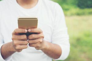 Man with smartphone in hand,Nature park, blurred background. photo