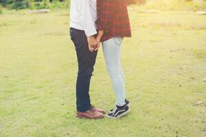 Feets of you young couple kissing in the park. Couple in love. photo