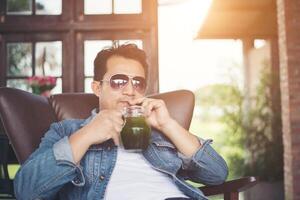 Young man with smartphone smiling relaxing at cafe. photo