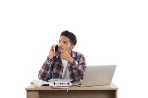 hombre de negocios hablando por teléfono mientras trabaja con una laptop en la oficina aislada de fondo blanco. foto