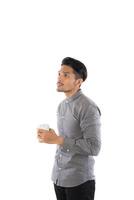 apuesto joven hipster sosteniendo una taza de café de pie con aislado en fondo blanco. foto