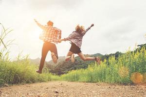 Hipster Teenagers Jumping at the flower field,Happy time,enjoy life. photo