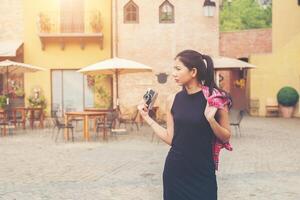 mujer hermosa joven con cámara retro, chica asiática de estilo retro vintage de vacaciones sonriendo feliz. foto