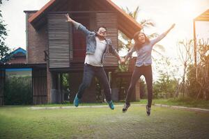 Hipster couple jumping high in the countryside. Couple in love concept. photo