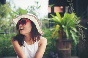 Portrait of charming woman relaxing on the deck chair outdoors with hat and glasses. photo