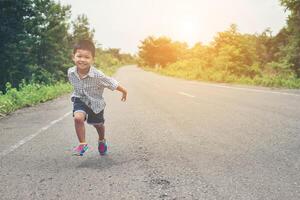 Happy little boy in motion, smiley running on the street. photo