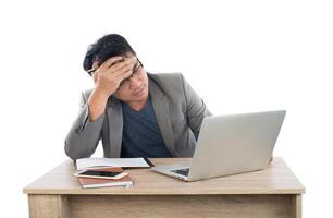 Stressed businessman work  with laptop sitting at table isolated on white background. photo