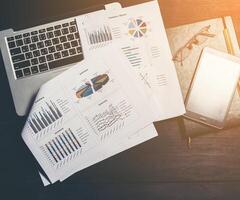Finance analytic, accounting or bussinesmen workplace.Top view. Laptop with financial graph on screen, table, documents, smartphone, notepad. photo