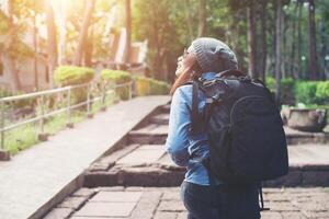 Young attractive woman tourist with backpack coming to ancient phanom rung temple in thailand. photo