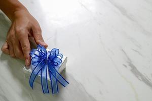 gift giving,man hand holding a gift box in a gesture of giving.blurred background photo