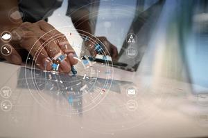 Hands of businessman using mobile phone in modern office with laptop and digital tablet computer in finance team meeting with VR icon diagram photo