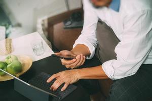 hipster hand using digital tablet docking keyboard and mobile payments online business,omni channel,sitting on sofa in living room,green apples in wooden tray,filter effect photo