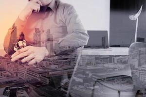 smart medical doctor holding stethoscope and thinking with laptop computer on dark wooden desk in modern office photo