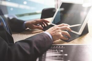 Businessman hand working concept. Documents finance graphic chart. Digital tablet keyboard dock screen computer design smart phone using. Eyeglass on marble desk. Sun flare effect photo