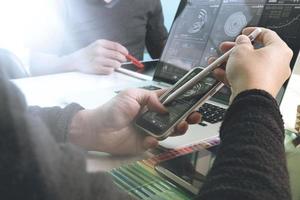 Photo website graphic designer hand working with new project modern studio.Modern laptop digital tablet smart phone on wood table.Books papers documents. Blurred background, sun flare effect