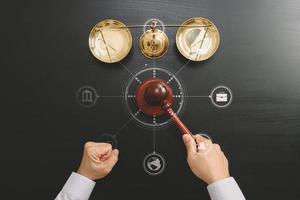 justice and law concept.Top view of Male judge hand in a courtroom with the gavel and brass scale on dark wood table with Vr diagram photo